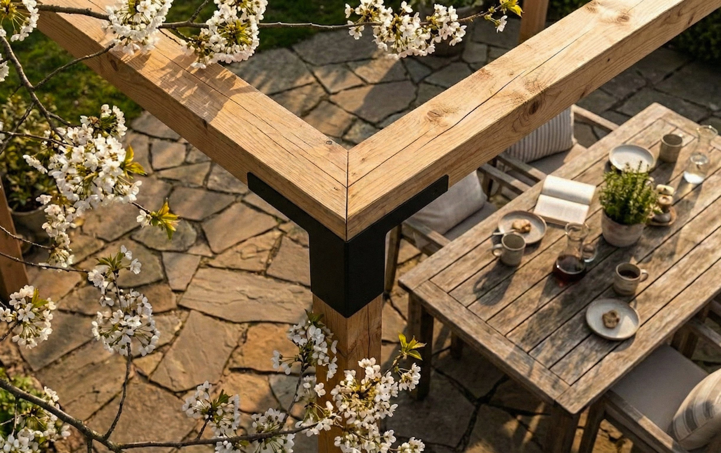 Wooden outdoor table with flowers and a stone patio