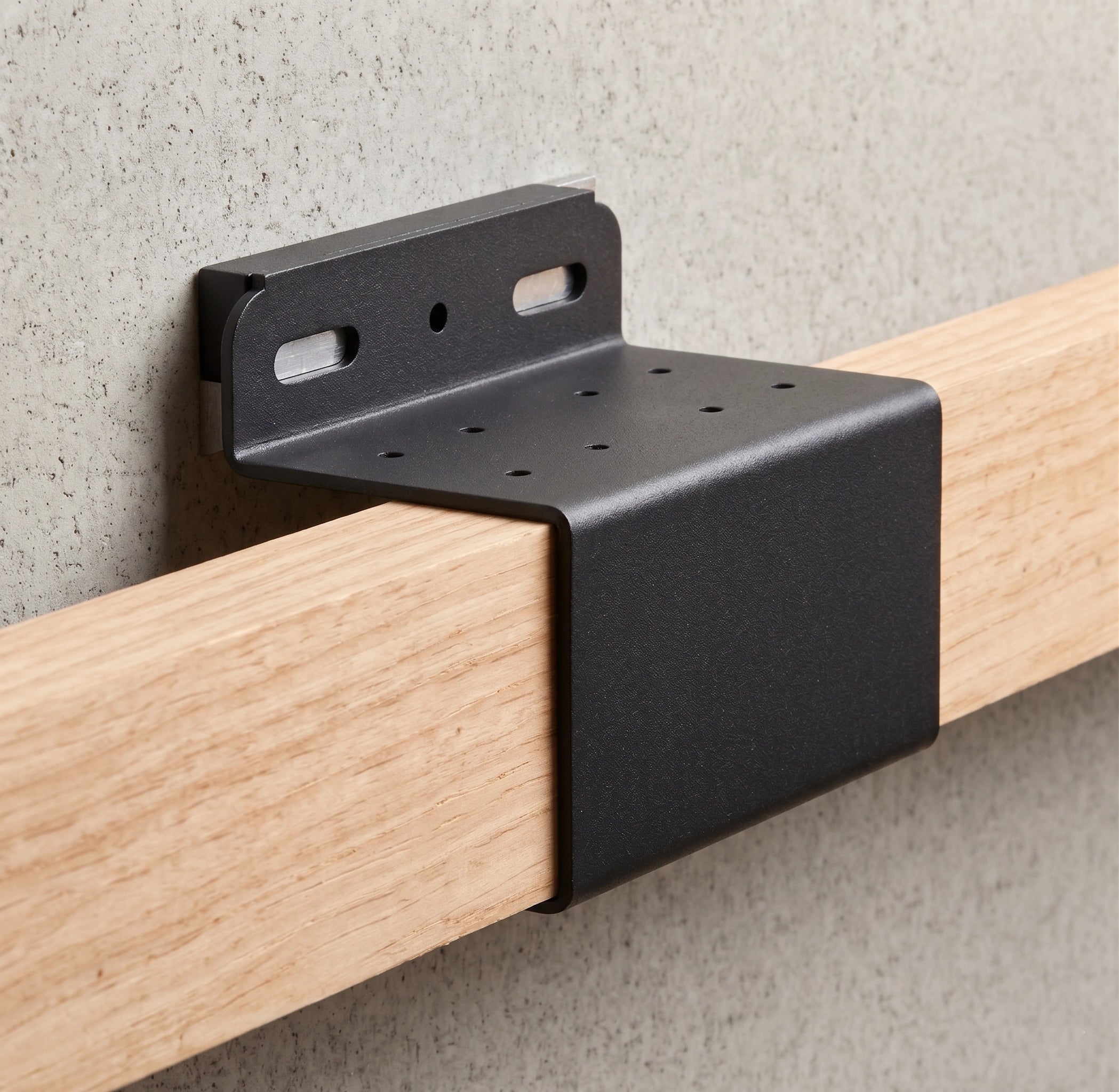 Black metal bracket attached to a wooden rod against a gray concrete wall.